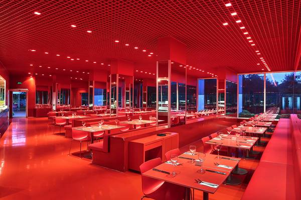 Roter Saal im Su Hotel mit roten Tischen, Stühlen und Deckenbeleuchtung.