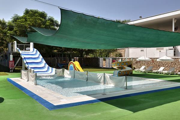 Ein Kinderpool mit Rutschen und Sonnenschirmen im Freien im Hotel.