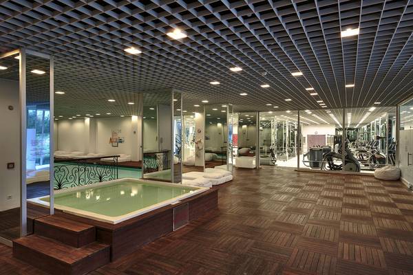 Innenansicht des Su Hotels mit einem großen Innenpool und Fitnessbereich.