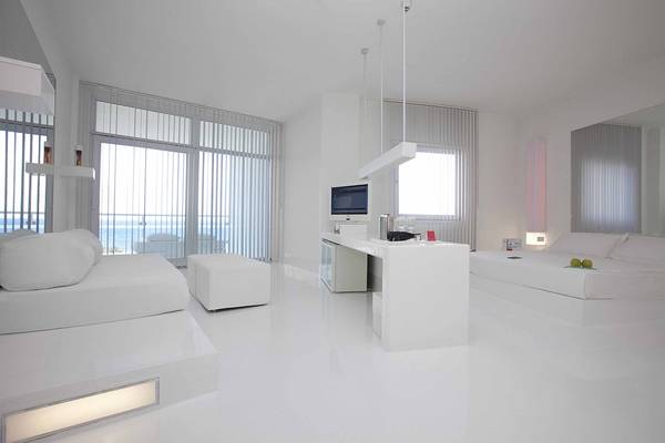 Modernes, minimalistisches Zimmer im Su Hotel mit weißen Möbeln und Meerblick.
