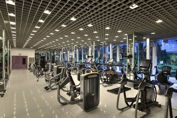 Innenansicht des Fitnesscenters im Su Hotel mit vielen Trainingsgeräten und großen Fenstern.