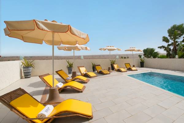 Pool-Terrasse mit Sonnenliegen und Sonnenschirmen im VOI Praia De Chaves Resort