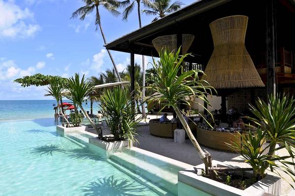 Außenpool des Anantara Rasananda Koh Phangan Villas mit Blick auf das Meer und Palmen