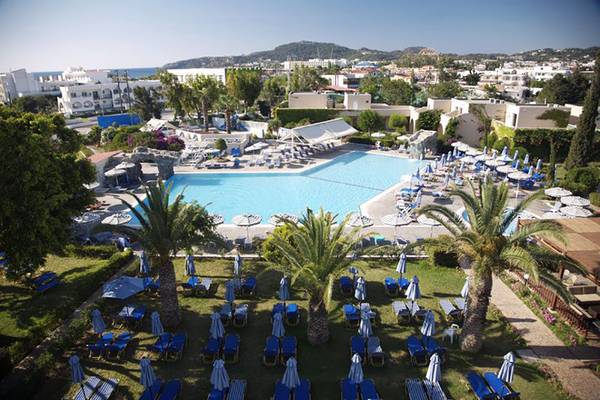 Luftaufnahme des Sun Palace Hotels mit Swimmingpool, Liegestühlen und Sonnenschirmen.