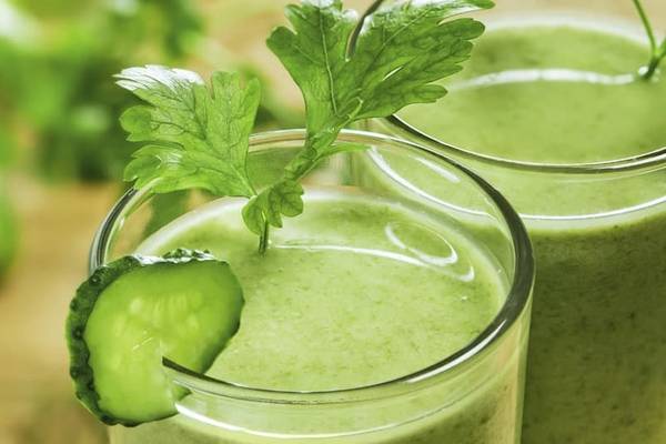 Zwei Gläser mit grünem Smoothie und Gurke, das Hotel Anantara Rasananda Koh Phangan Villas im Hintergrund