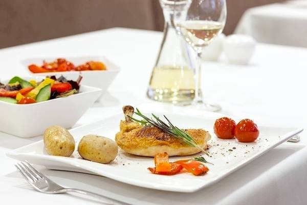 Ein Gericht im NH Hamburg Altona mit Hähnchen, Kartoffeln, Gemüse und Wein.