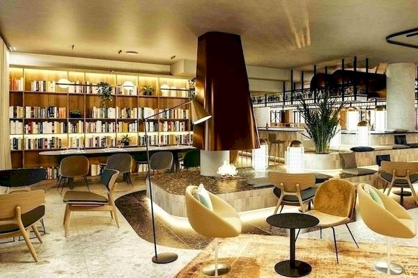 Lobby des NH Hamburg Altona Hotels mit Bücherregal, Sitzbereichen und Dekorationspflanzen.