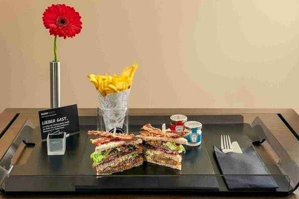 Ein Tisch mit einem Sandwich, Pommes und Ketchup im NH Hamburg Altona Hotel.