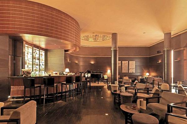 Innenansicht der Bar im Atlas Medina & Spa Hotel mit Bar, Klavier und Sitzmöbeln.