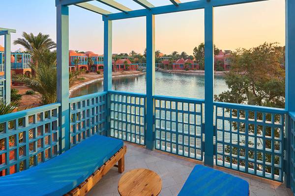 Blick vom Balkon des Sheraton Miramar Resort El Gouna auf einen See und Hotelgebäude