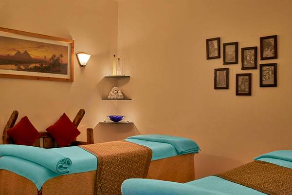 Behandlungsraum im Sheraton Miramar Resort El Gouna mit zwei Massageliegen und dekorativen Elementen an der Wand.