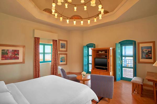 Suite-Zimmer im Sheraton Miramar Resort El Gouna mit Bett, Fernseher, Tisch und Balkon