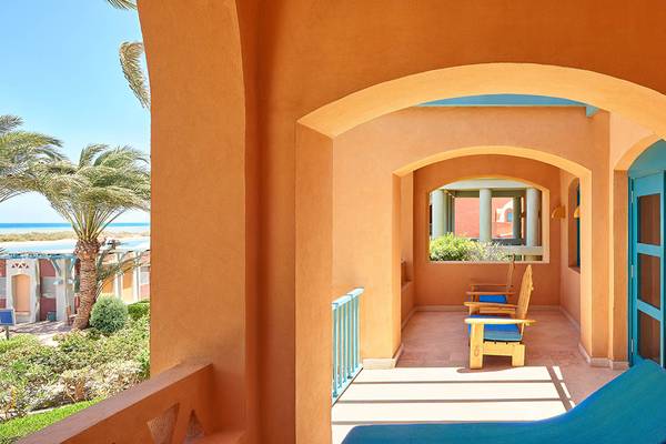 Blick von der Balkon des Sheraton Miramar Resort El Gouna auf die Terrasse mit zwei Stühlen und einem Tisch.