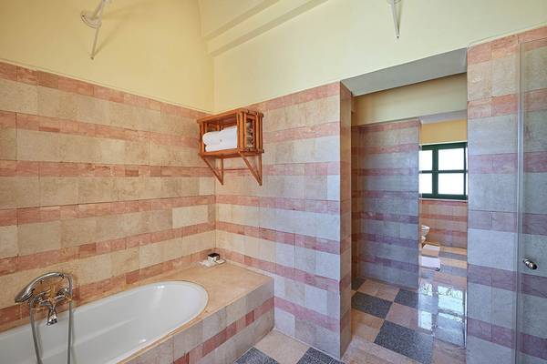 Badezimmer im Sheraton Miramar Resort El Gouna mit Badewanne, Dusche und gefliesten Wänden.