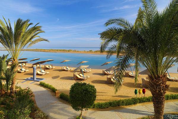 Luftaufnahme des Sheraton Miramar Resort El Gouna Strand mit Sonnenliegen und Sonnenschirmen