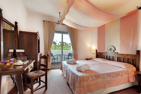Doppelzimmer im Colonna Grand Hotel Capo Testa mit zwei Betten und Balkon.