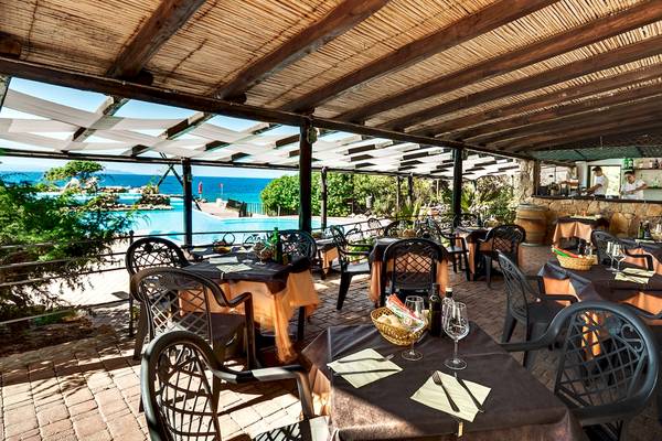 Terrasse des Colonna Grand Hotel Capo Testa mit Blick auf den Pool.