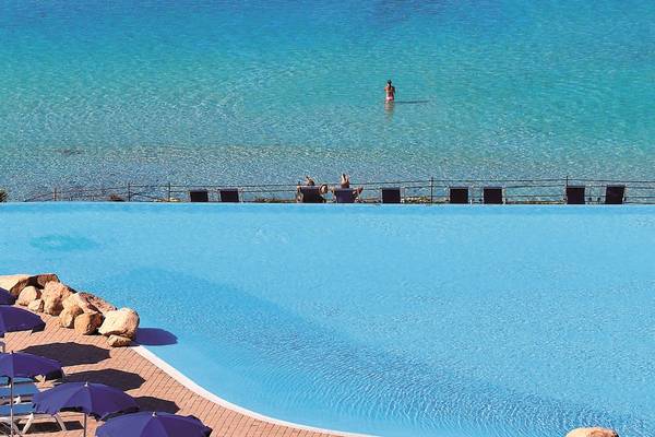 Außenpool des Colonna Grand Hotel Capo Testa mit Blick auf das Meer.