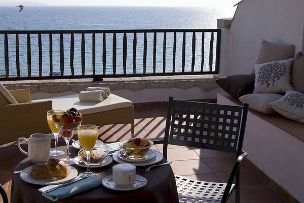 Frühstück auf der Terrasse des Colonna Grand Hotel Capo Testa mit Blick auf das Meer.