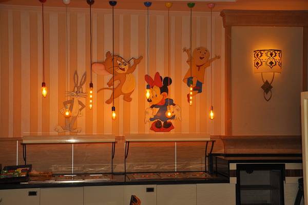 Restaurant mit Wandgemälden von Zeichentrickfiguren wie Tom und Jerry, Bugs Bunny, Minnie Mouse und Charlie Chaplin.