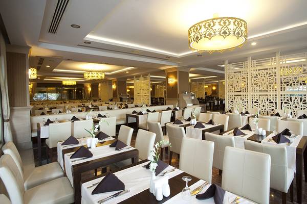 Restaurant des Aydinbey Kings Palace & Spa mit gedeckten Tischen und dekorativen Elementen.