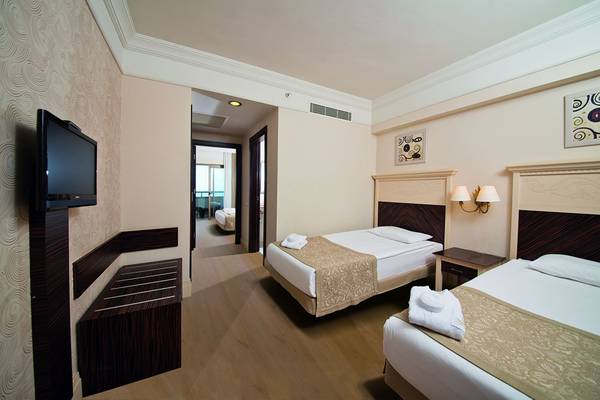 Doppelzimmer im Aydinbey Kings Palace & Spa mit zwei Betten, Fernseher und Nachttischen.
