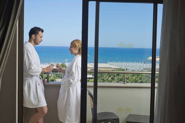 Paar im Bademantel genießt Wein auf dem Balkon mit Meerblick im Aydinbey Kings Palace & Spa