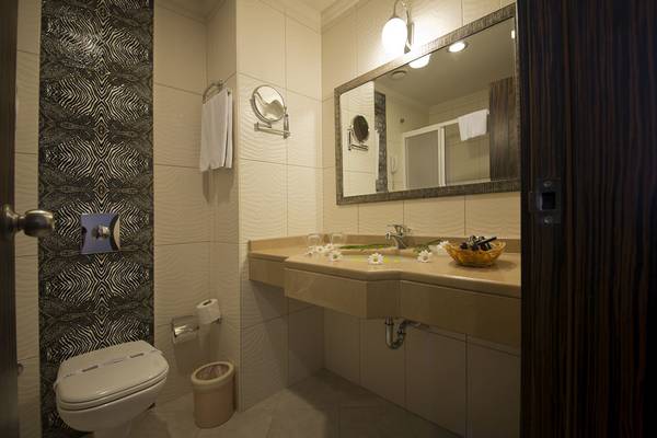 Badezimmer im Aydinbey Kings Palace & Spa mit zeitgenössischem Design, Toilette, Waschbecken und Spiegel.