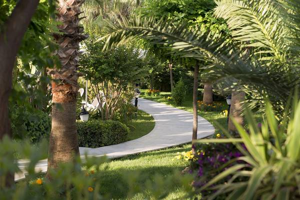 Gartenweg im Aydinbey Kings Palace & Spa Hotel mit Palmen und Blumen