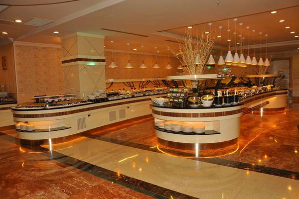Buffetrestaurant im Aydinbey Kings Palace & Spa Hotel mit vielen Speisen und hängenden Lampen.