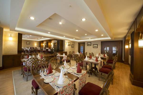 Innenansicht des Restaurants des Aydinbey Kings Palace & Spa mit gedeckten Tischen und Stühlen.