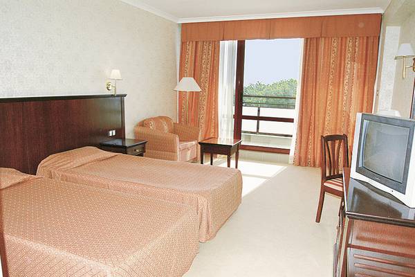 Doppelzimmer im Gladiola Star Hotel mit zwei Betten, Fernseher und einem Balkon.