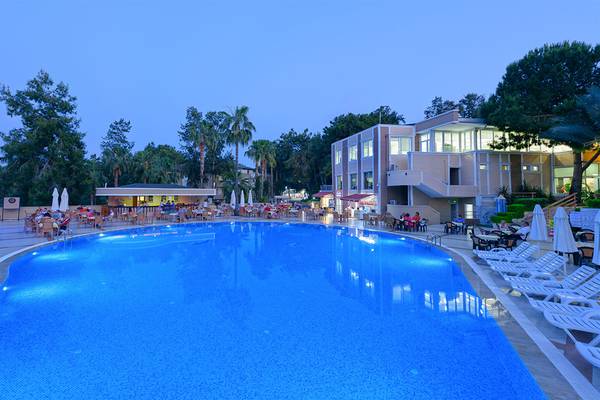 Außenbereich des Club Hotel Sidelya mit großem Pool, Lounge-Stühlen und umliegenden Bäumen