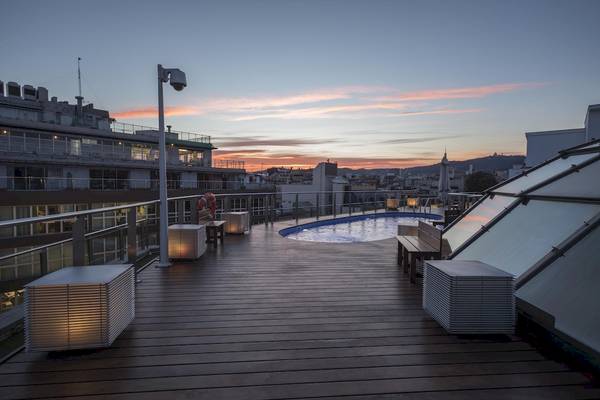 Dachterrasse des Gran Hotel Havana Barcelona bei Sonnenuntergang mit Swimmingpool und Stadtblick