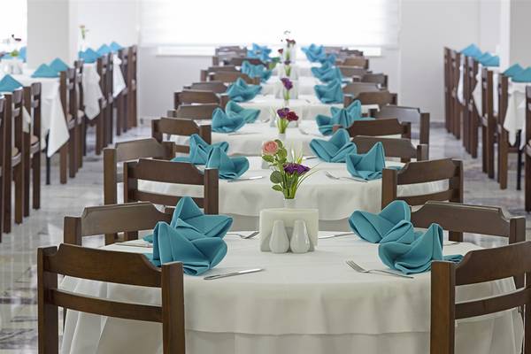 Club Hotel Sidelya Restaurant mit gedeckten Tischen und Blumenarrangements.