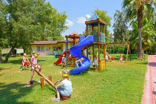 Kinder spielen auf dem Spielplatz im Club Hotel Sidelya, mit einer Rutsche und Schaukeln.