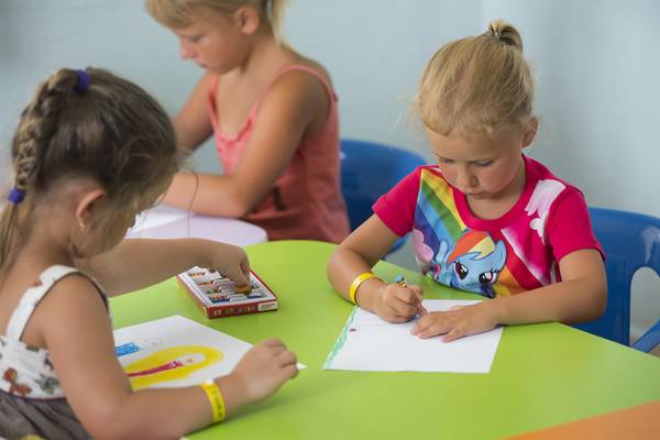 Kinder im Club Hotel Sidelya zeichnen an einem grünen Tisch.