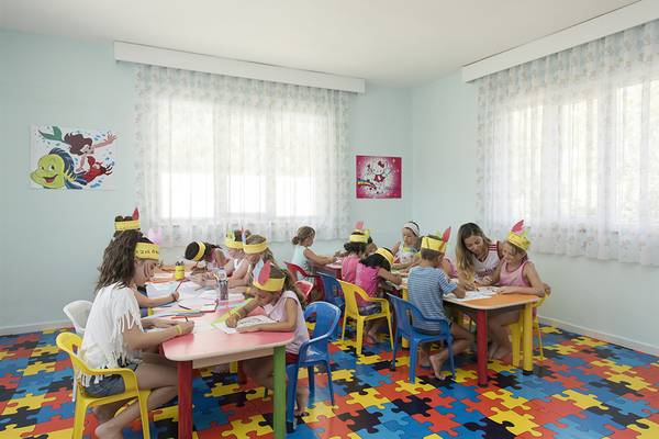 Kinder machen einen Workshop im Club Hotel Sidelya, alle tragen traditionelle Kopfbedeckungen.