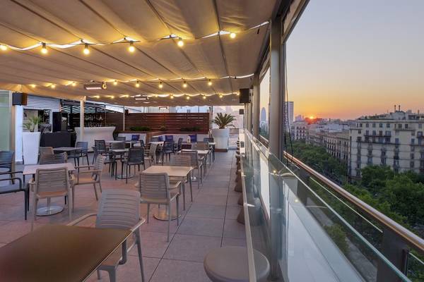 Außenterrasse des Gran Hotel Havana Barcelona mit Blick auf die Stadt bei Sonnenuntergang.