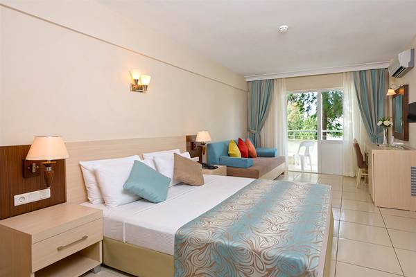 Innenansicht eines Hotelzimmers im Club Hotel Sidelya mit Bett, Sofa und Balkon