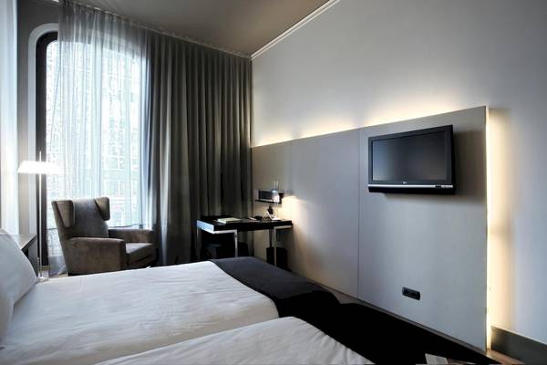 Innenansicht des Doppelzimmers im Gran Hotel Havana Barcelona mit zwei Betten, Schreibtisch und Fernseher an der Wand.