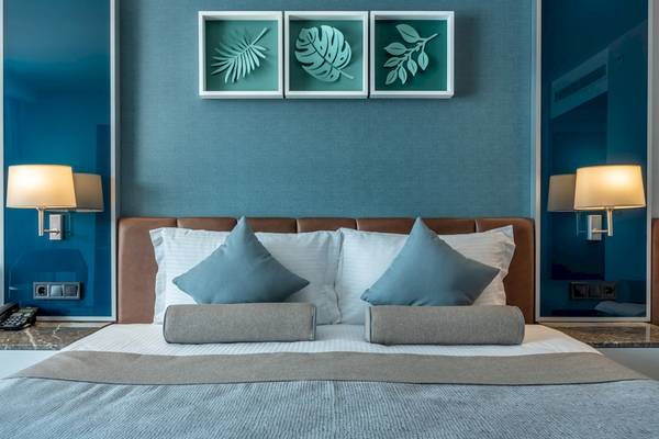 Hotel Baia Lara Schlafzimmer mit blauen Wand und modernem Bett.