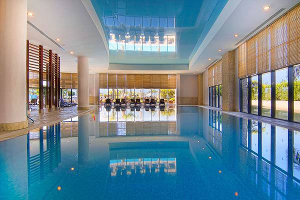 Großer Innenpool des Baia Lara Hotels mit blauen Decken und reflektierenden Wänden.