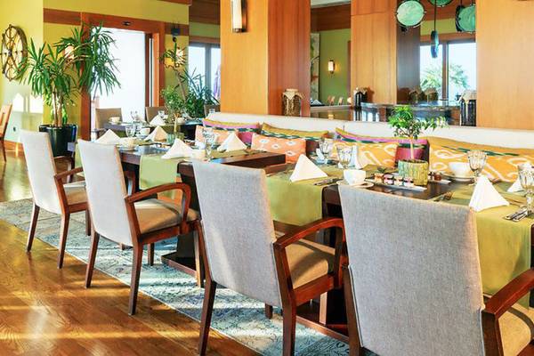 Speisesaal des Kempinski Hotel Barbaros Bay Bodrum mit gedecktem Tisch und bunten Kissen.