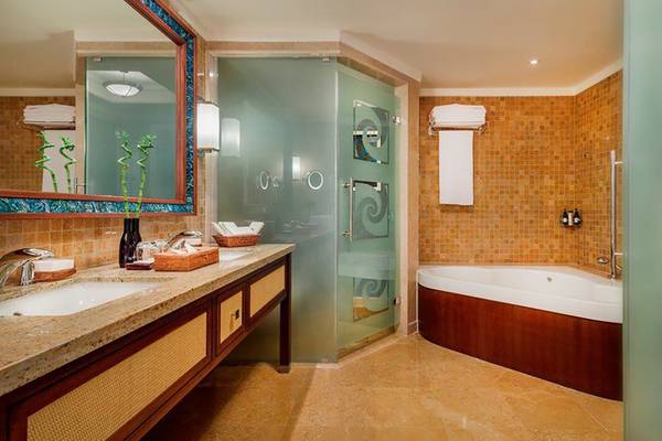 Badezimmer im Kempinski Hotel Barbaros Bay Bodrum mit Badewanne, zwei Waschbecken und Glasdusche.