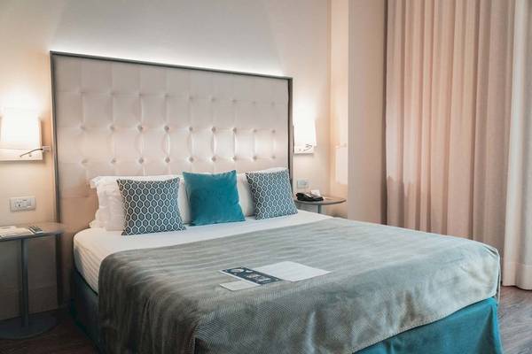 Schlafzimmer im Gran Hotel Havana Barcelona mit bequemem Bett und Dekor