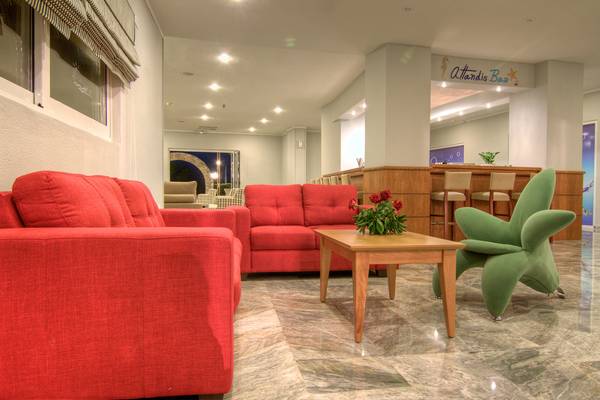 Hotellobby mit roten Sofas, Tisch und grünem Stuhl im Solimar Dias Hotel.