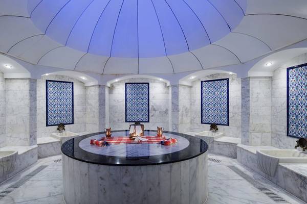 Innenansicht der Sauna im Liberty Hotels Lara mit blauen Mustern an den Wänden und einer zentralen Rundbank.