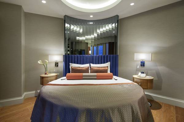 Schlafzimmer im Liberty Hotels Lara mit einem großen Bett, zwei Nachttischen und einem großen Spiegel.