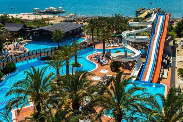 Luftaufnahme des Liberty Hotels Lara mit Pool, Wasserrutschen und Meer
